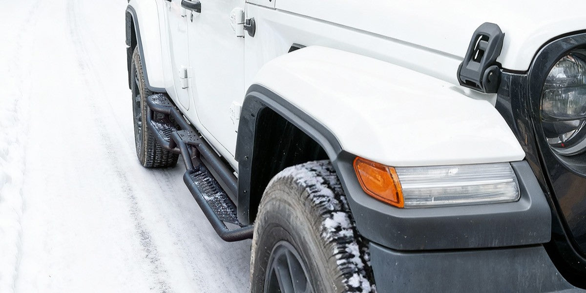 The car is installed with fixed running boards running on snowy roads.