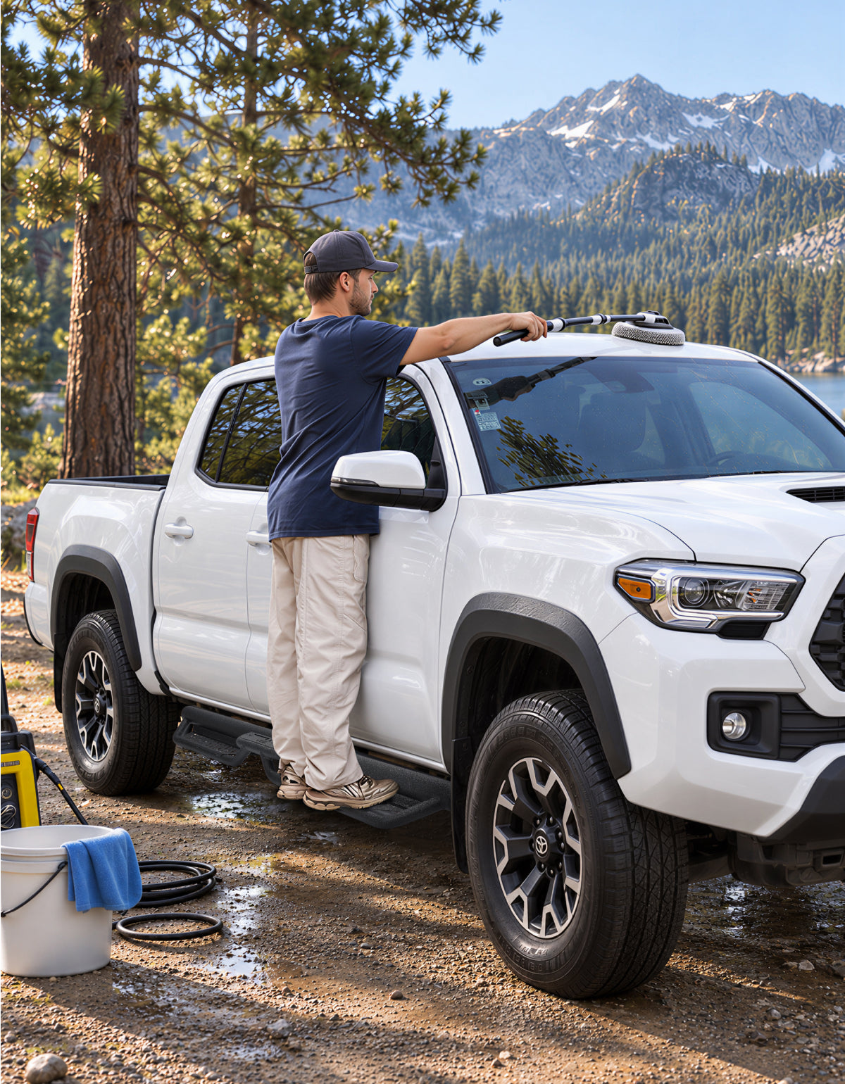 A man standing on Toyota Tacoma running boards and cleaning his truck top